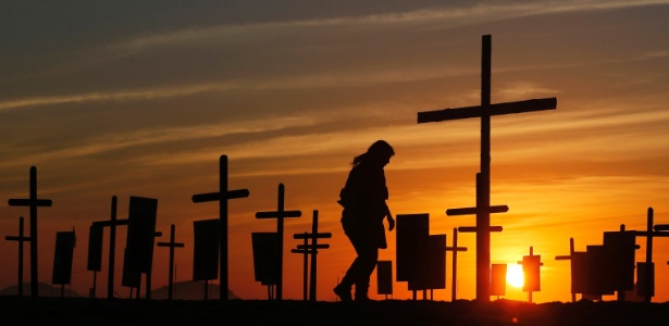 09dez2014---uma-policial-caminha-entre-cruzes-plantadas-pela-ong-rio-de-paz-na-praia-de-copacabana-na-memoria-de-policiais-mortos-no-rio-de-janeiro-1418136437124_615x300